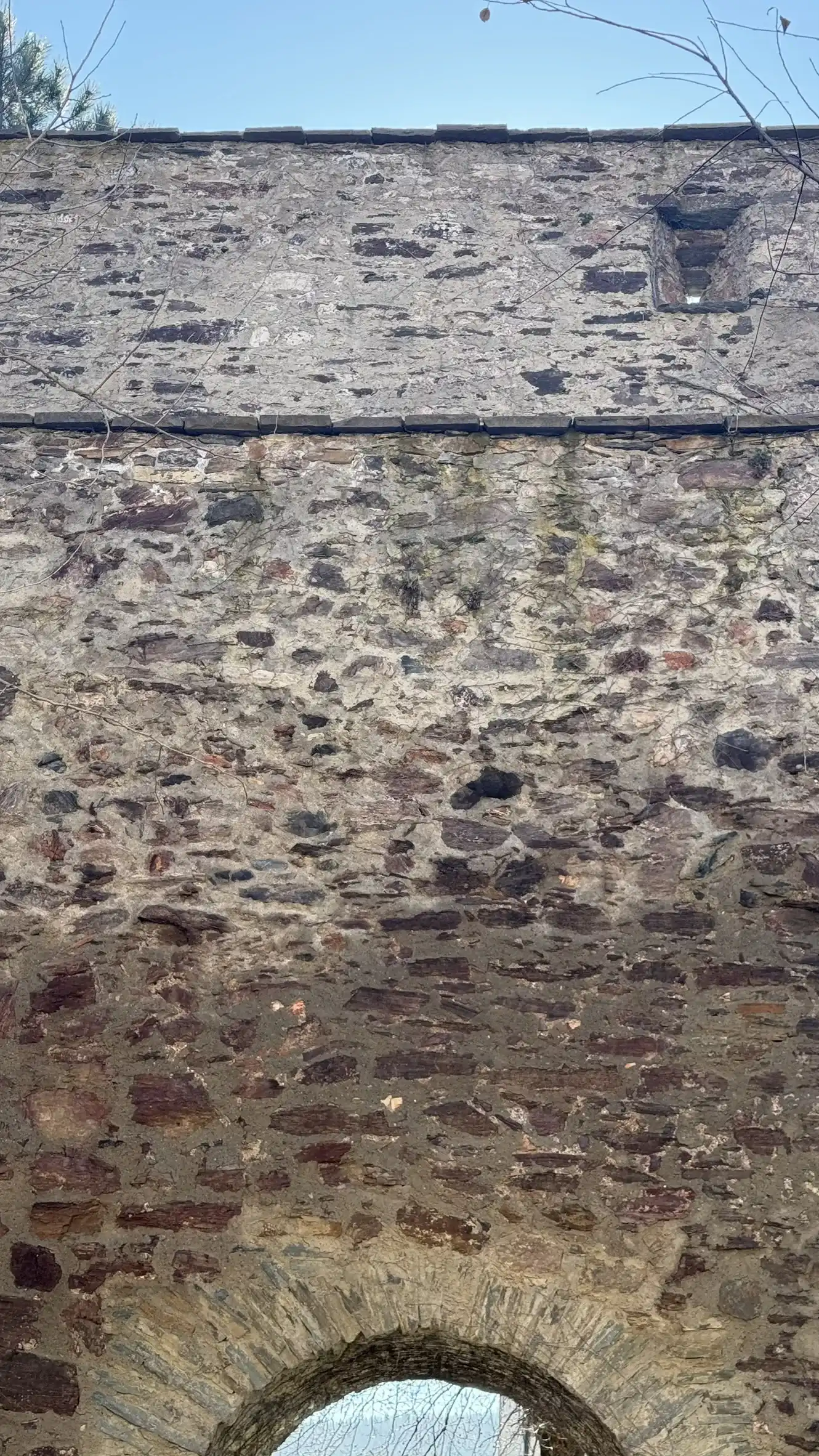 Der hohe Abschnitt der Mauer über dem bogenförmigen Tor