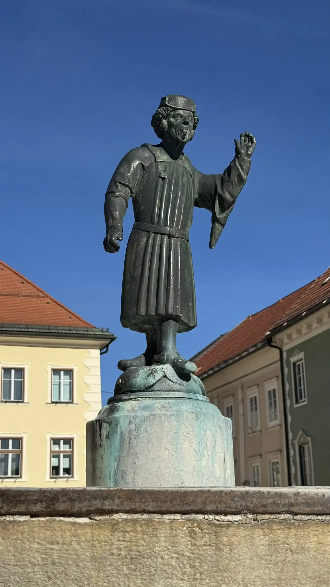 Der Brunnen wird von einer Bronzefigur bekrönt, die „Schüsselbrunnbartele“ genannt wird.