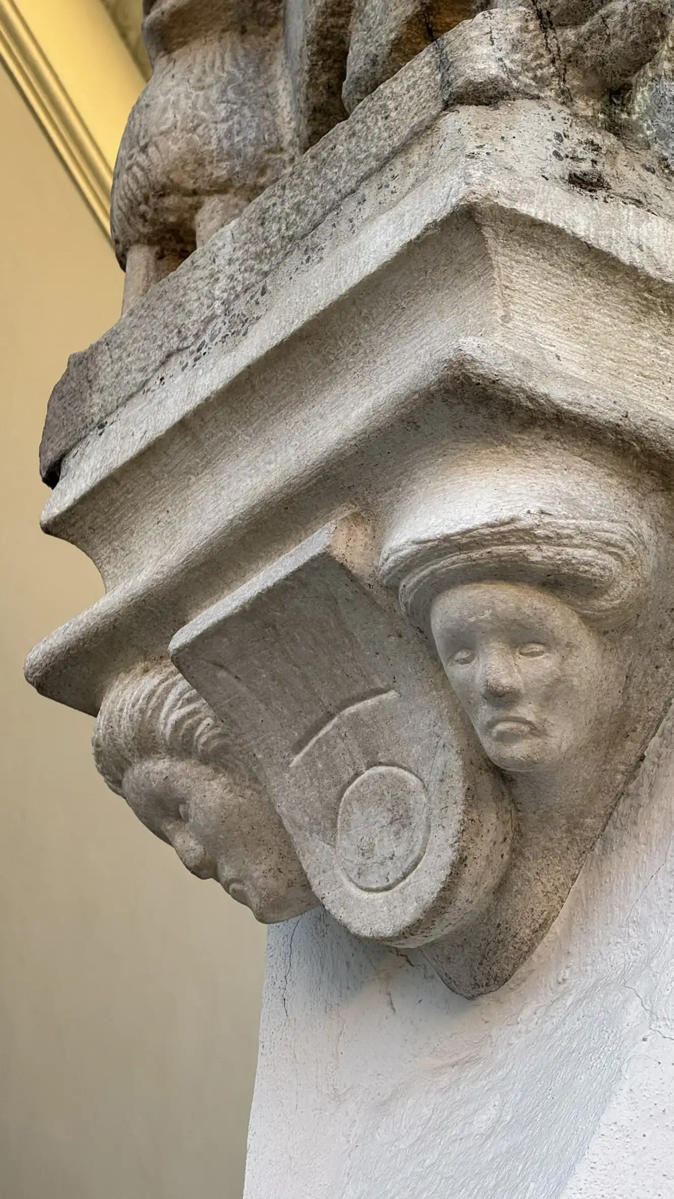 Two downward-gazing sculpted heads.