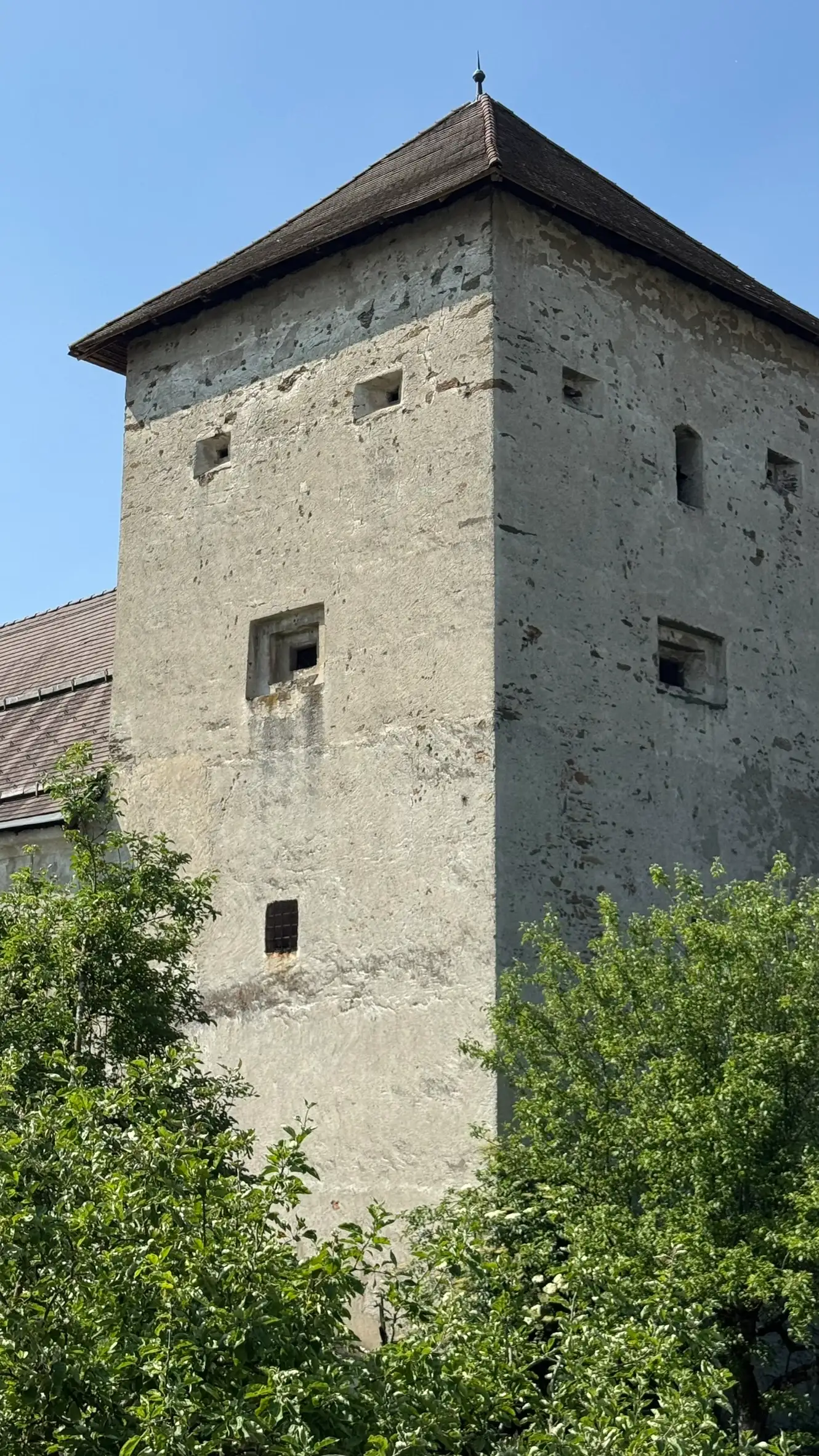 Five-storey defensive tower with small, square windows and embrasures