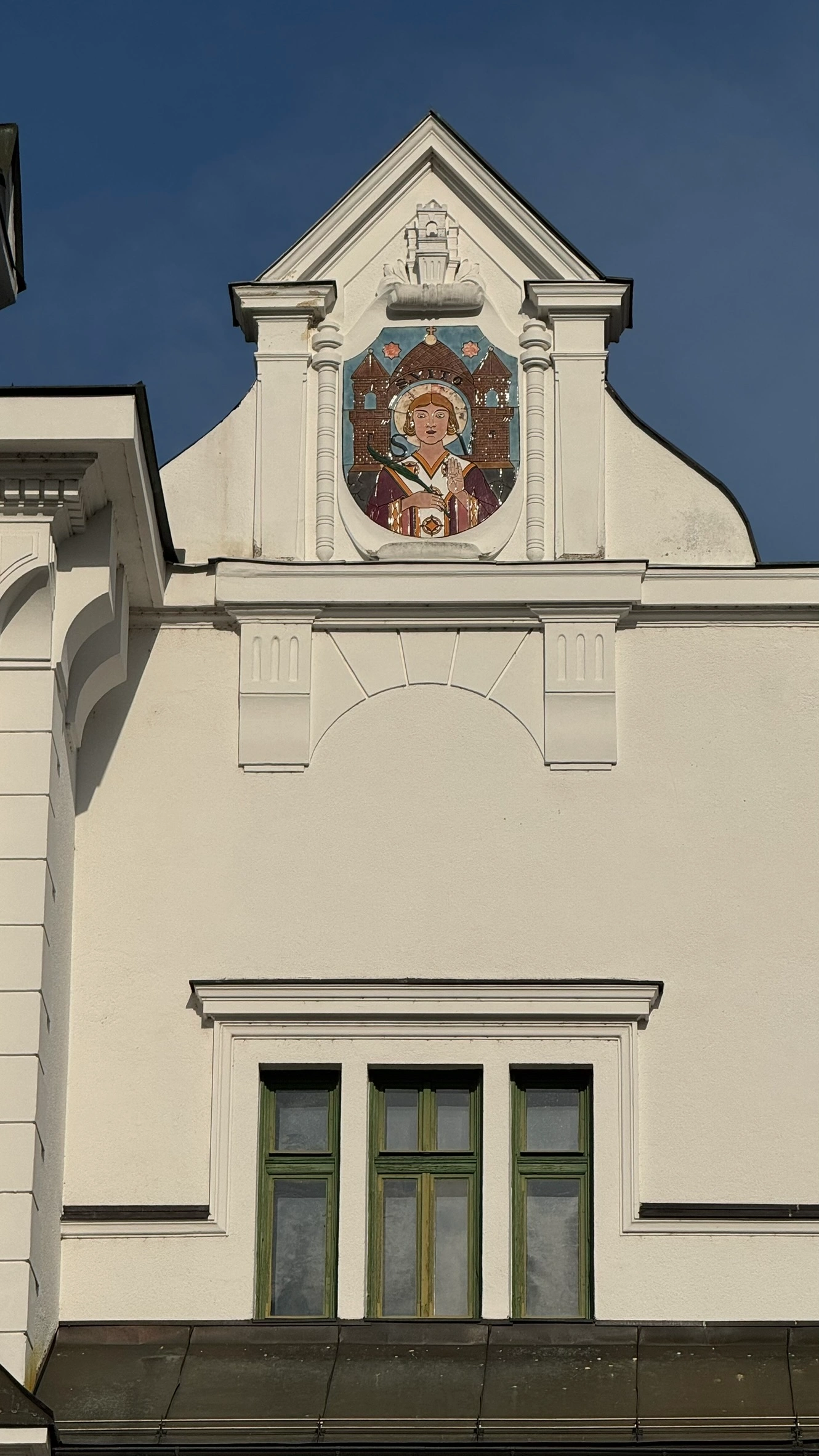 Triangular gable above a row of three narrow windows
