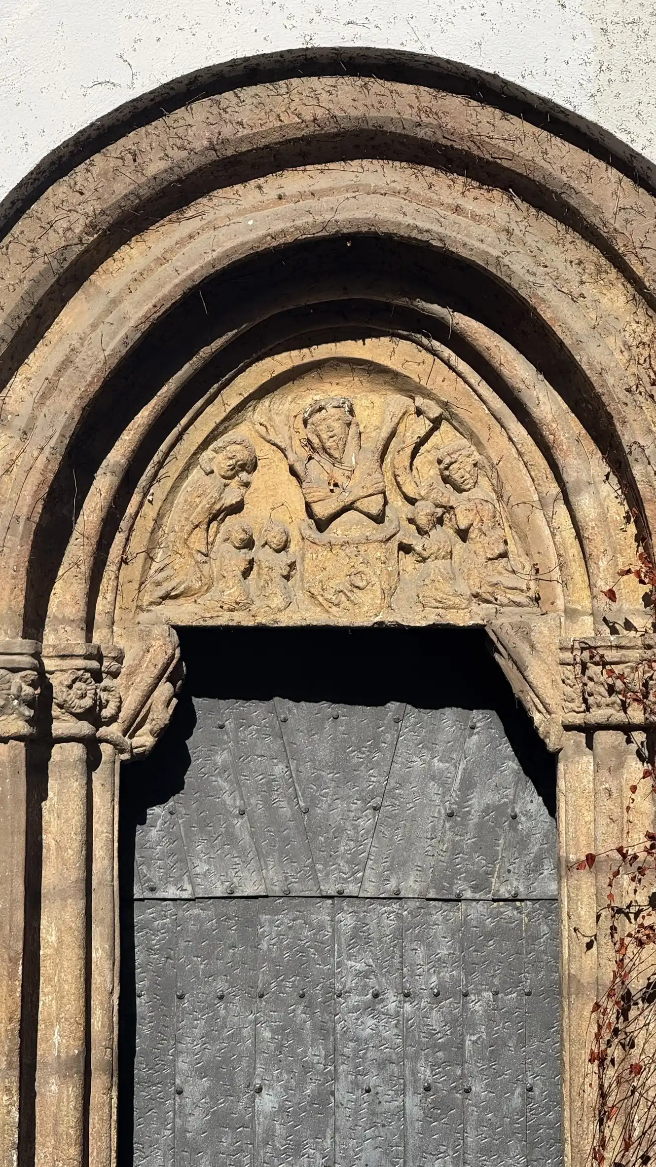 Tympanum relief depicting the Man of Sorrows with the kneeling donor family