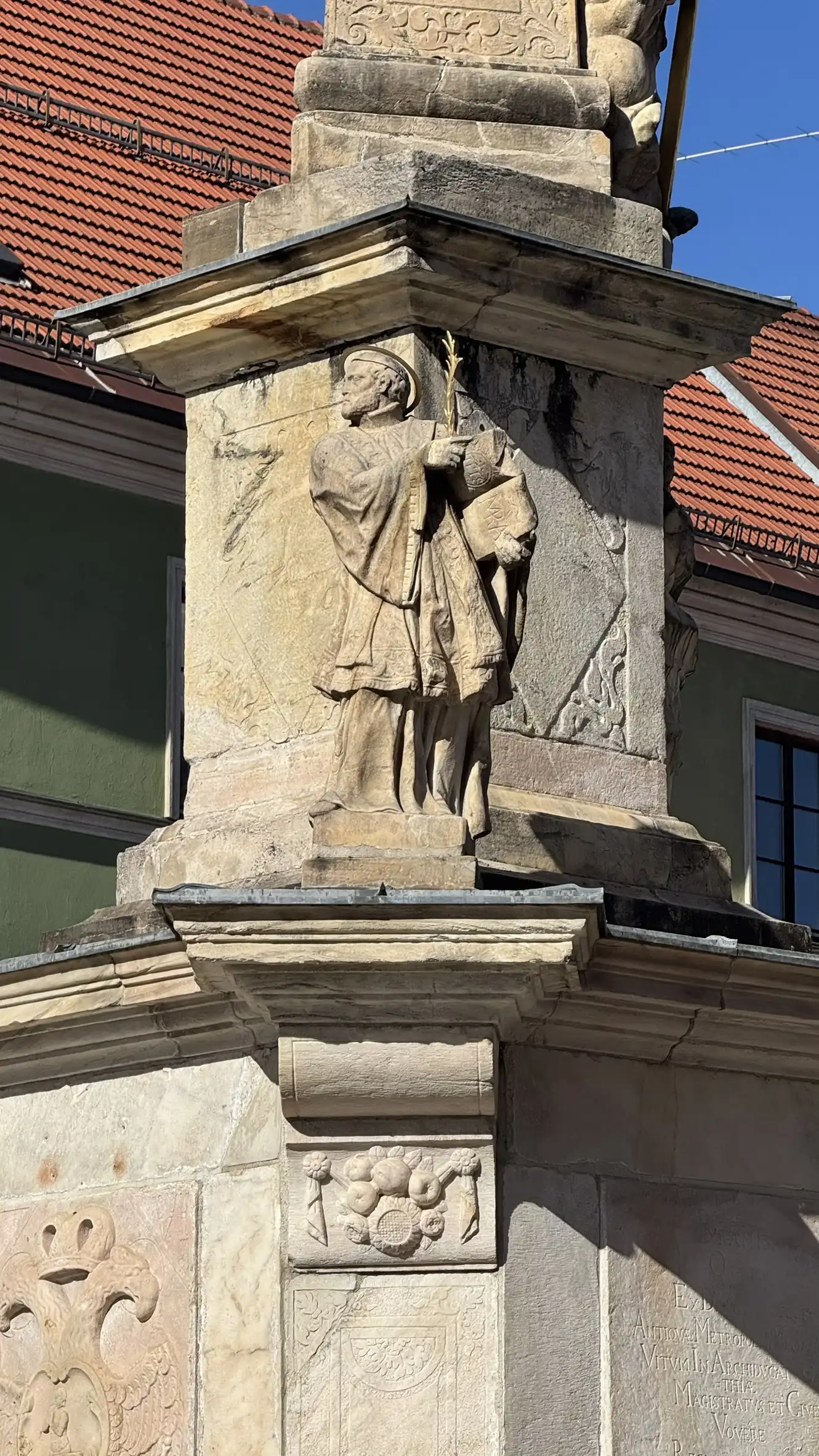 Statue: Saint John of Nepomuk standing on a broad cornice