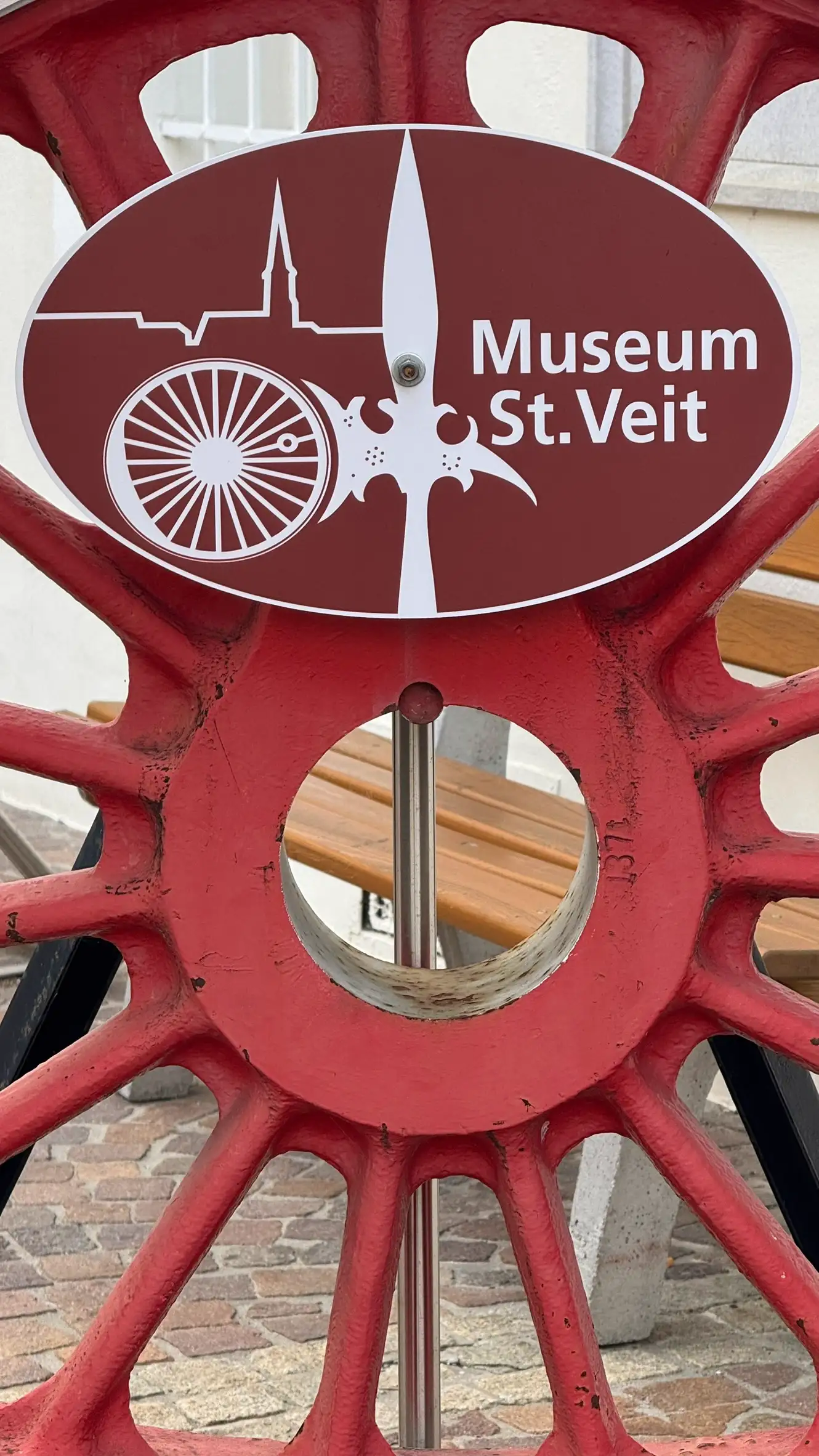 Informationstafel und Eisenbahnrad vor dem Museum