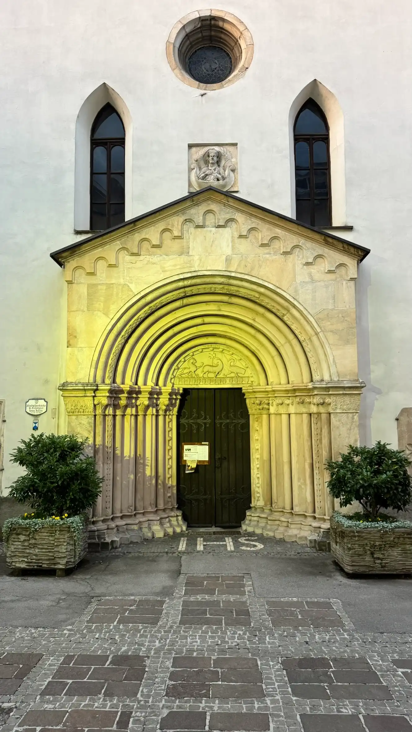 West portal, featuring tympanum, jambs, archivolts, two pointed windows, and a central circular window