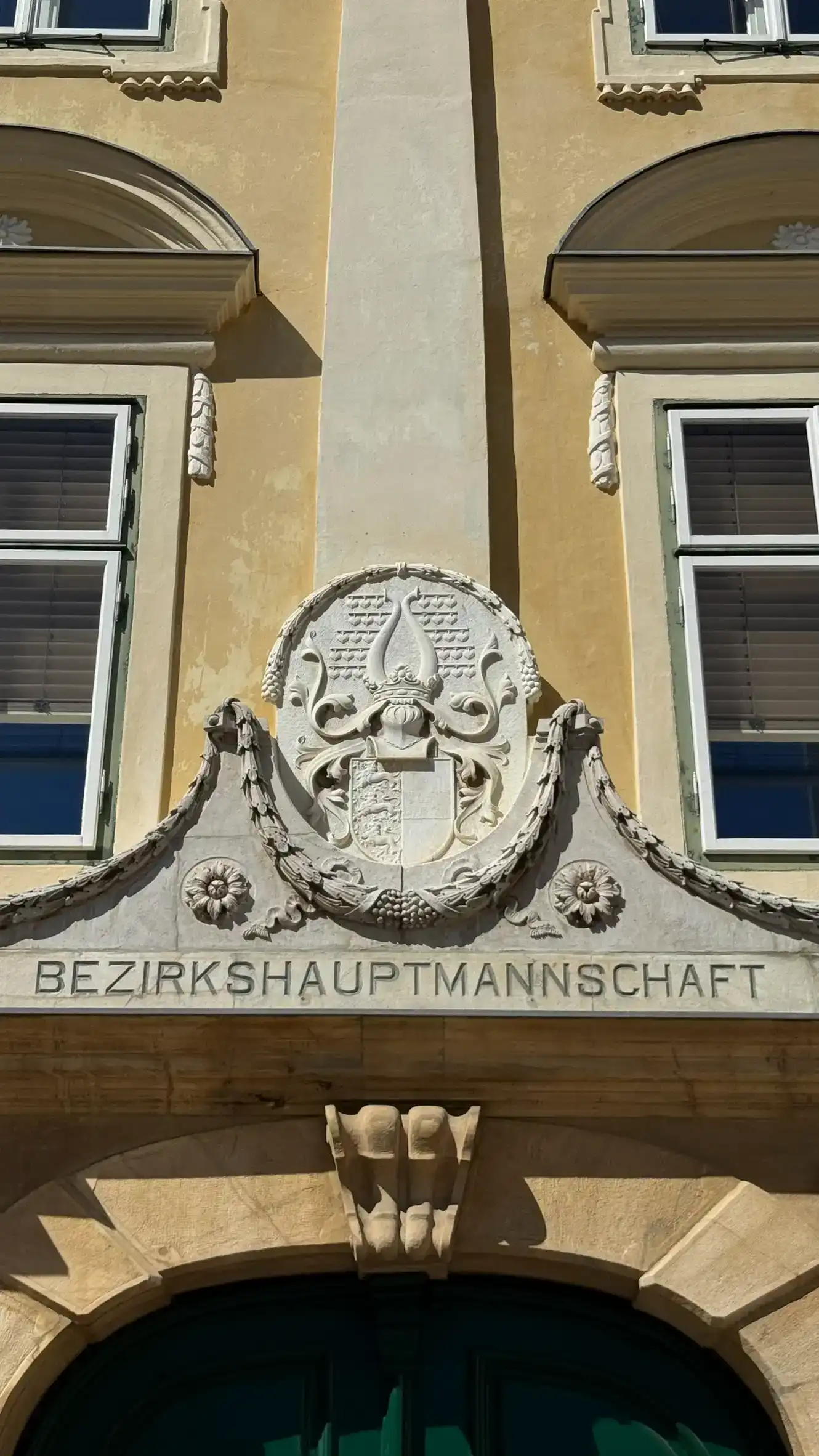 An oval "coat of arms" is positioned above the entrance.