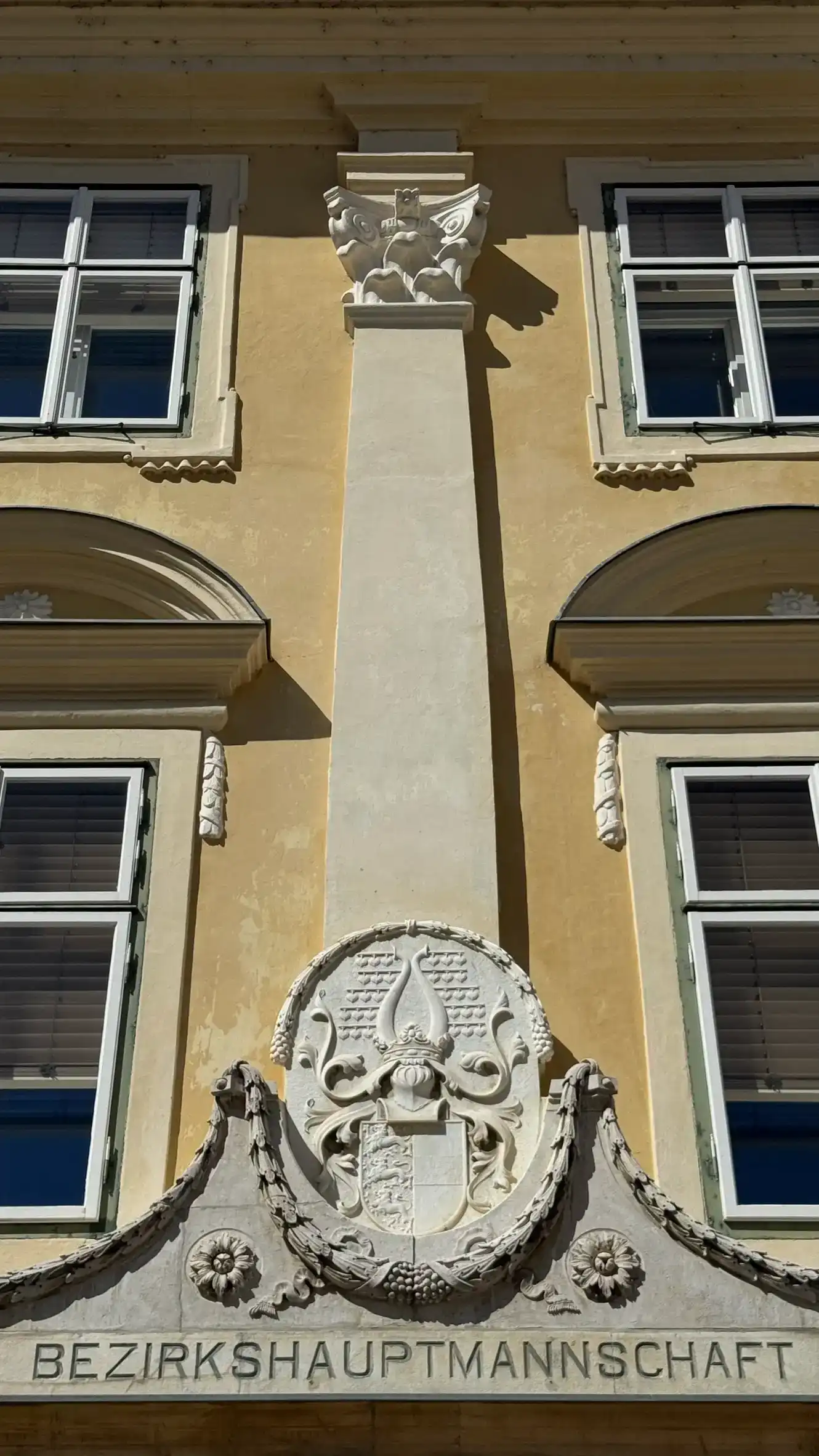 An oval "coat of arms" is positioned above the entrance.