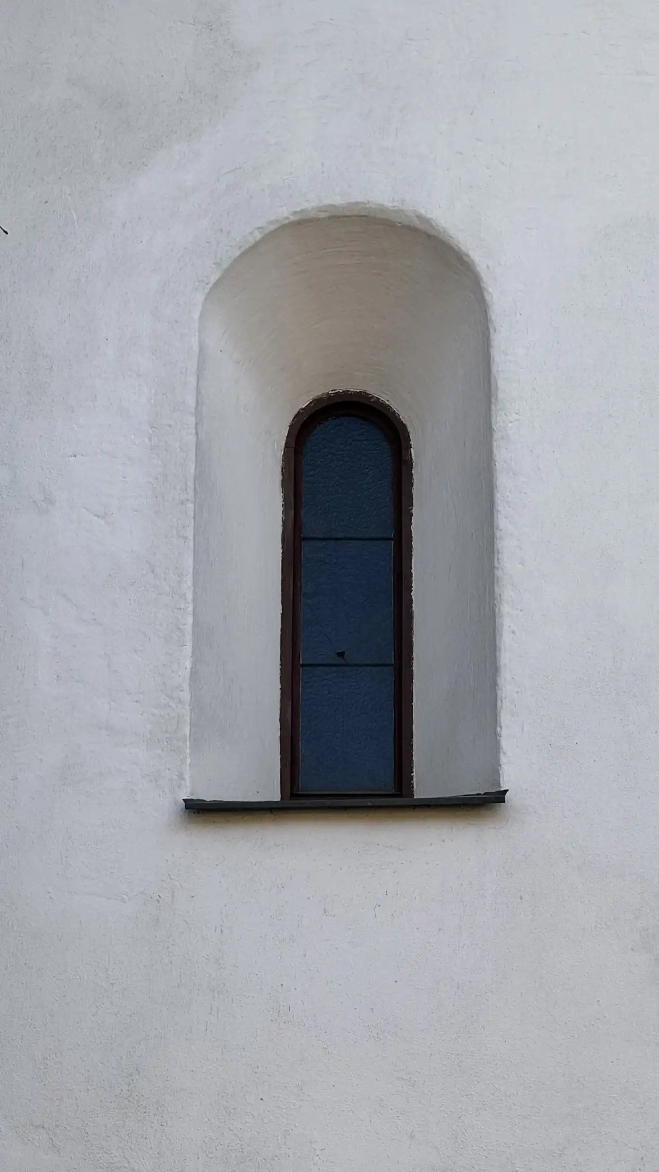 Close-up of recessed round-arched window