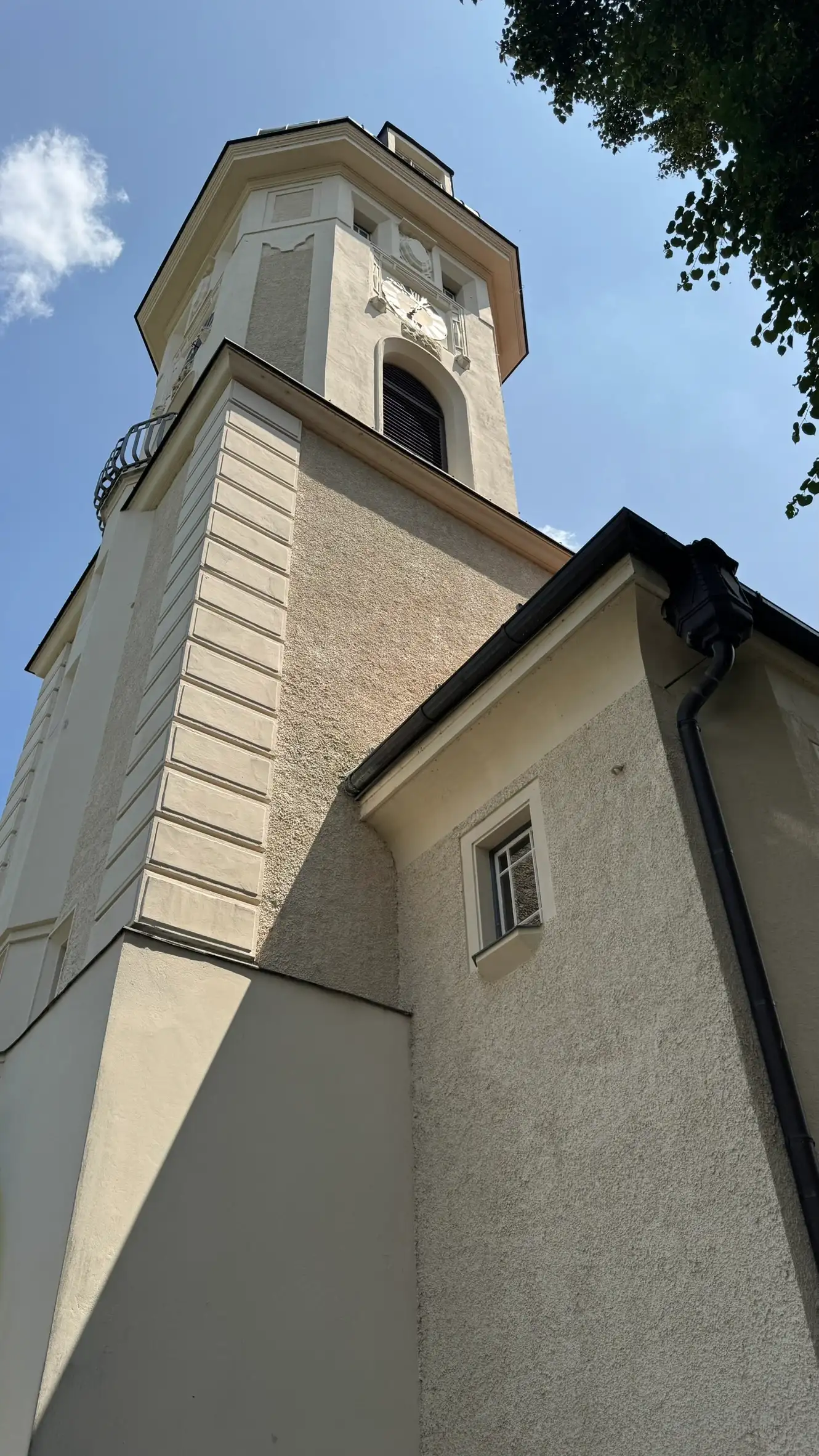 Three-part tower: cuboidal base, mid-section with quoins, octagonal upper section