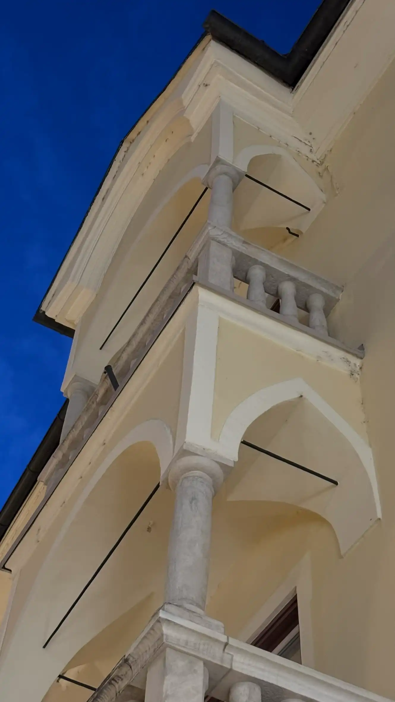 Projecting canopied balconies and balustrades of the upper two floors