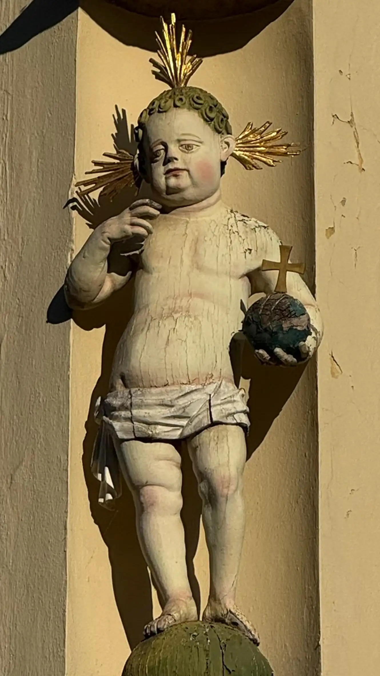 Das Jesuskind hält eine Weltkugel mit Kreuz.