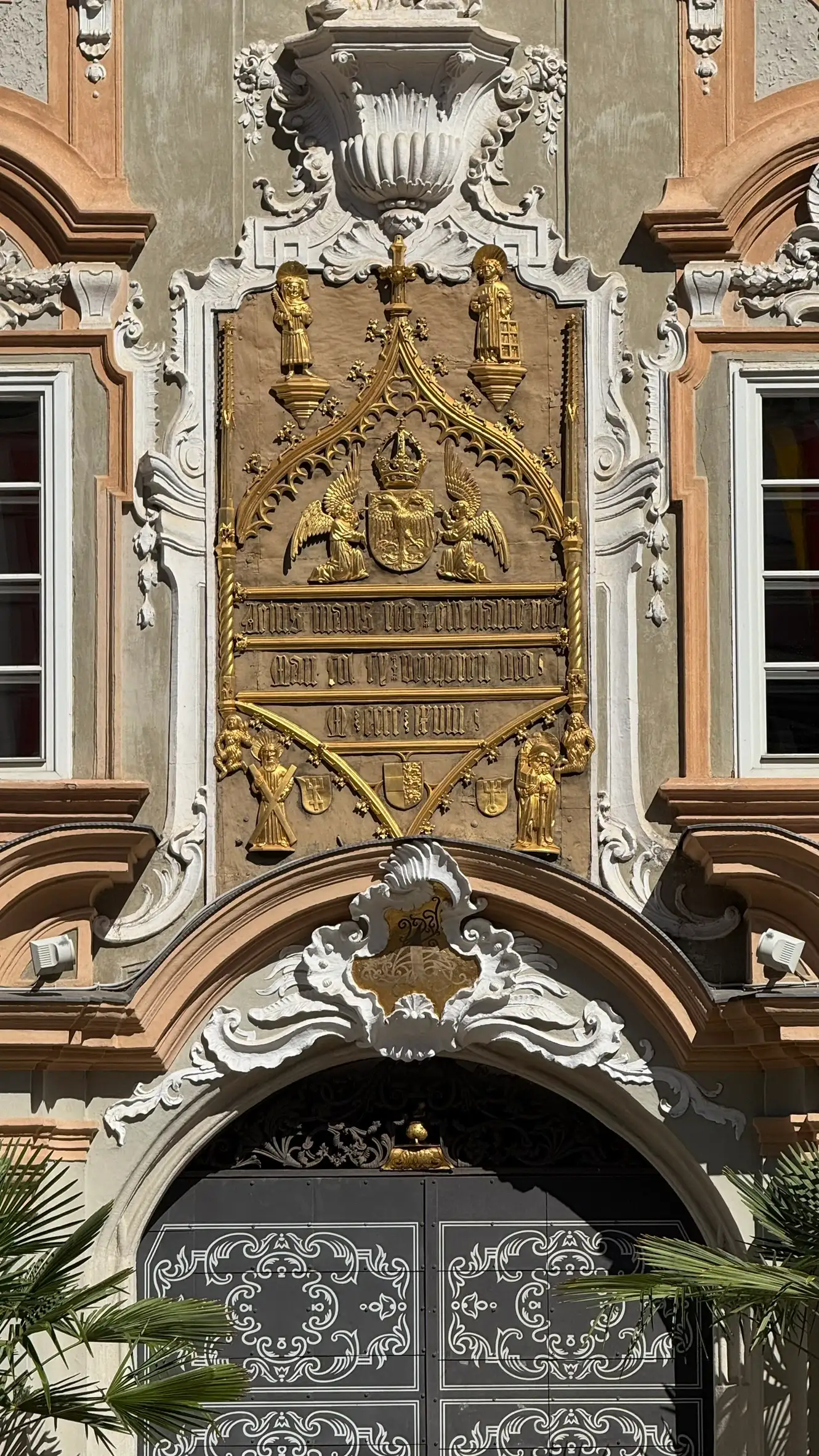 Metal cast plate above the arched portal