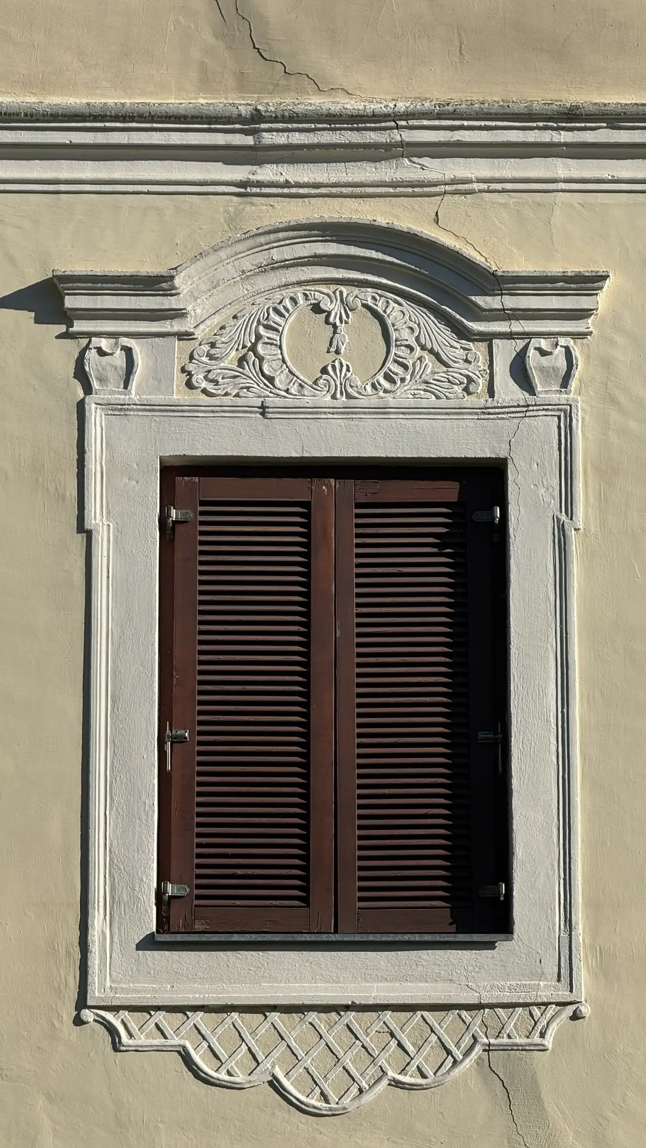 Close-up of a window with surround; pediment above the window; ornamentation above and below the window