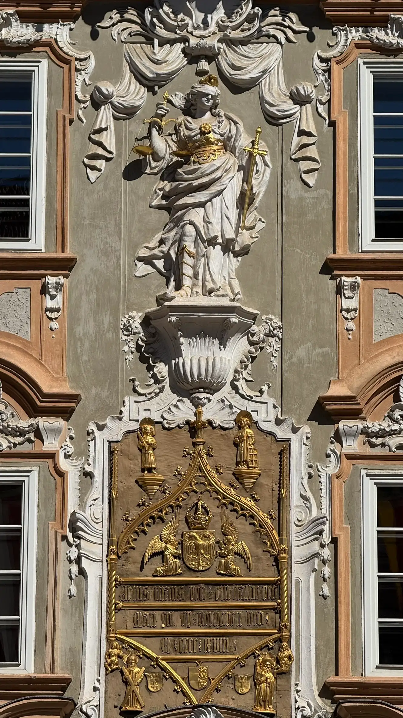 Justitia figure above the metal cast plate