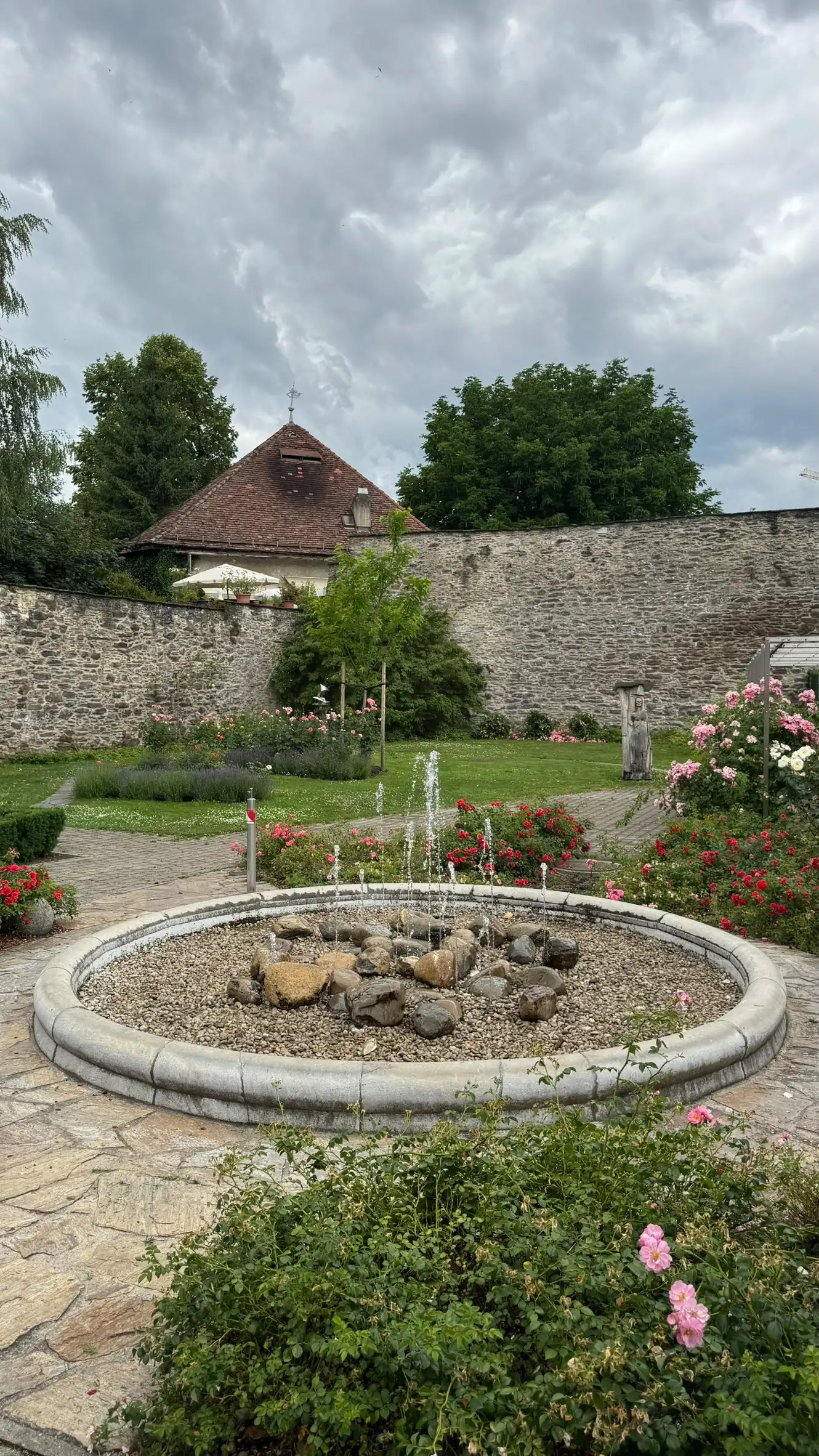 Vordergrund: bodenebener Brunnen; Hintergrund: Bastionsturm und westliche Ecke der Stadtmauer.