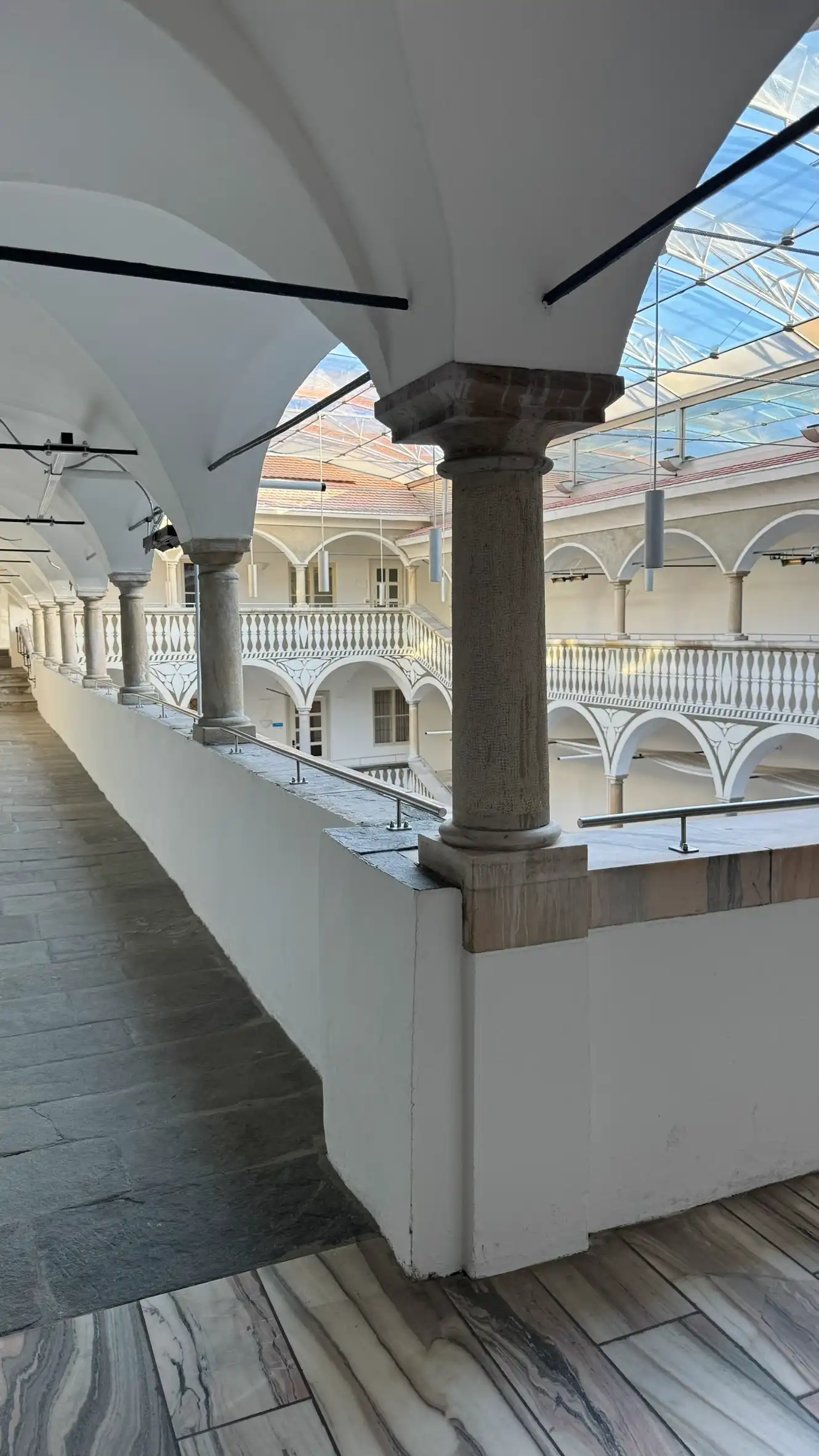 At the corners, the arcaded galleries meet at right angles, enclosing a rectangular courtyard.