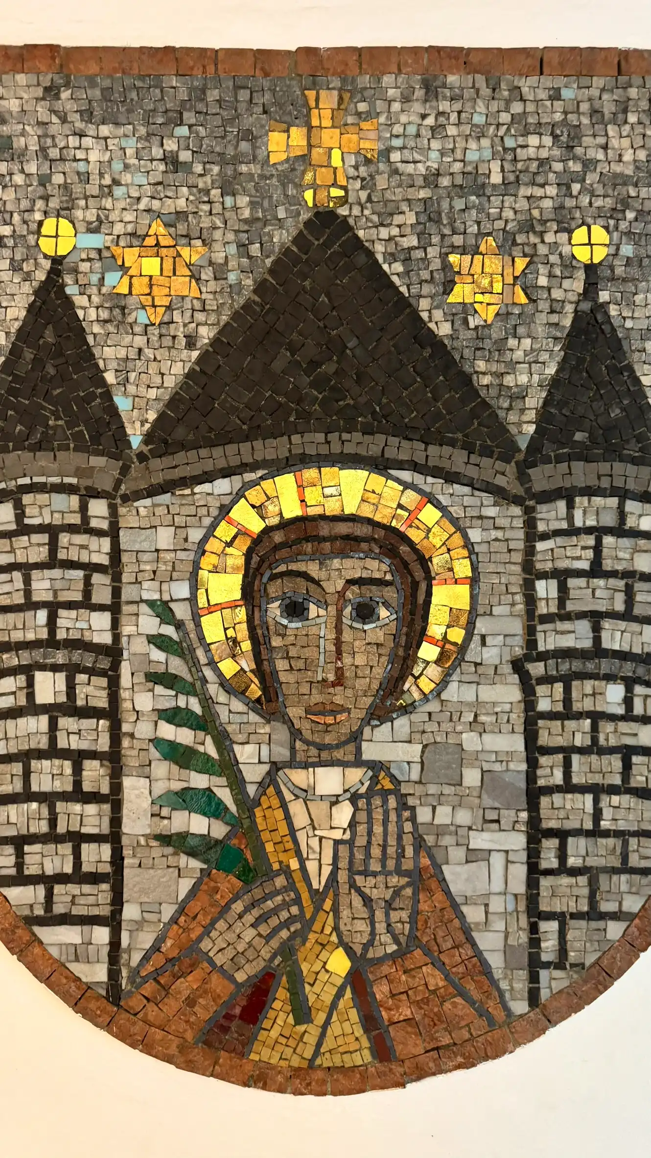 Der Kopf des heiligen Vitus ist von einem goldenen Heiligenschein umgeben. Seine Hände sind zum Gebet gefaltet, in der anderen hält er den grünen Palmzweig als Symbol des Martyriums.