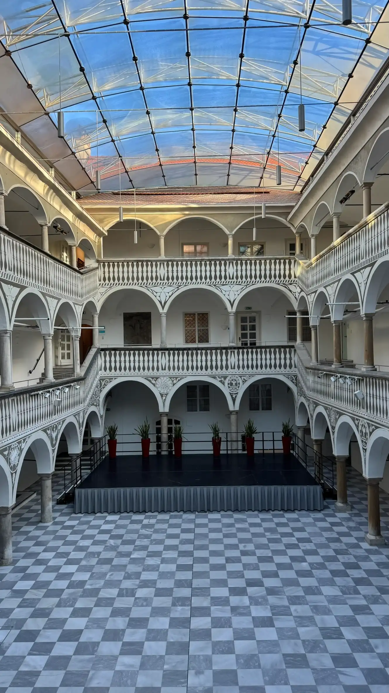 The rectangular arcaded courtyard rises through three storeys.