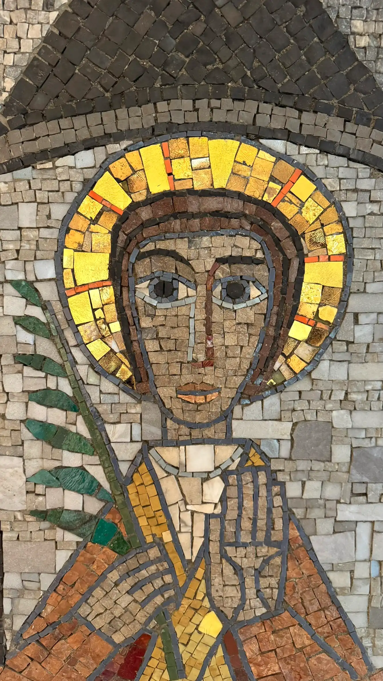 The background is formed of grey tesserae, while the saint is depicted in brown, with a golden halo.