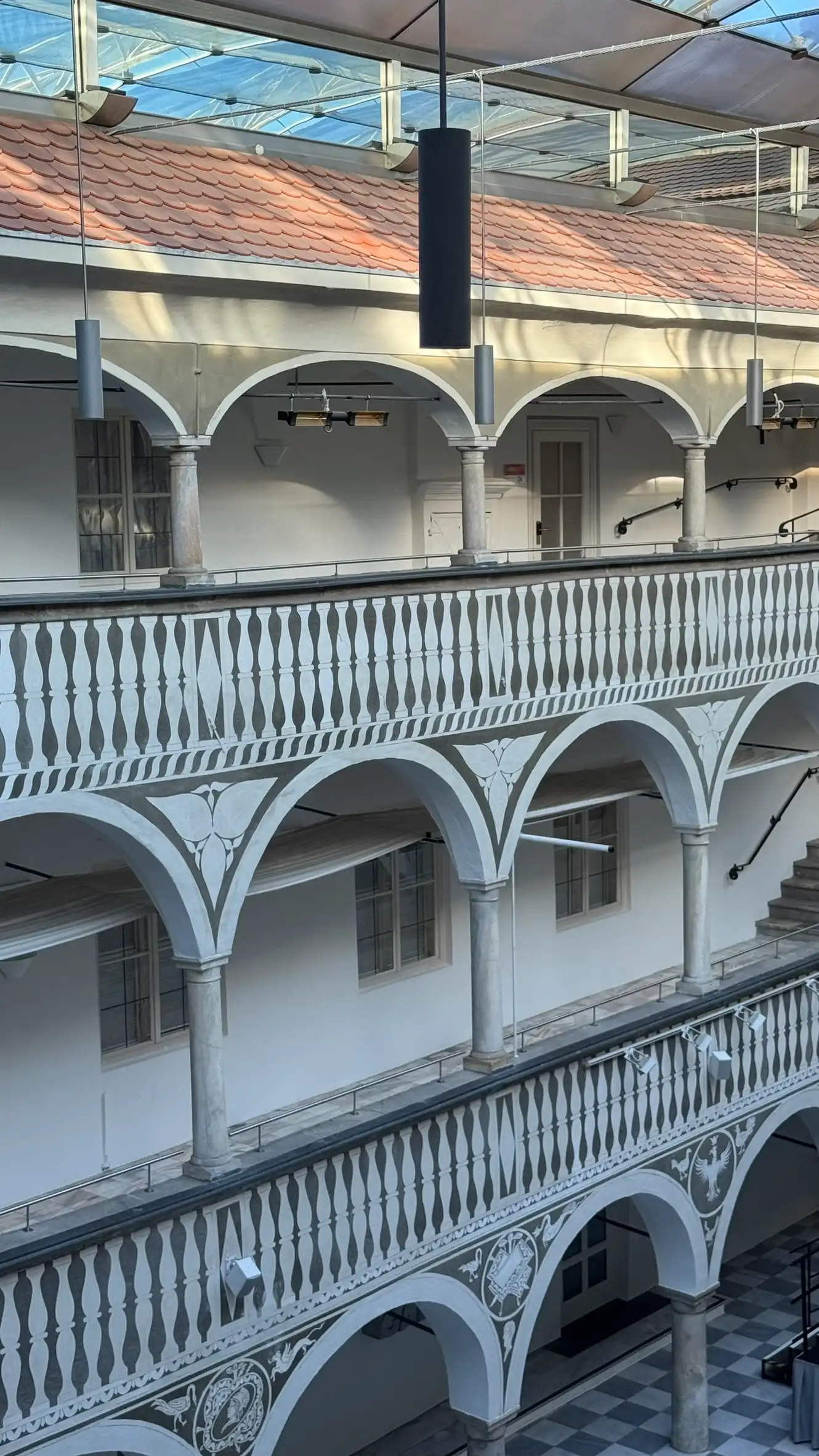 Each storey features round-arched arcades supported by stone columns.