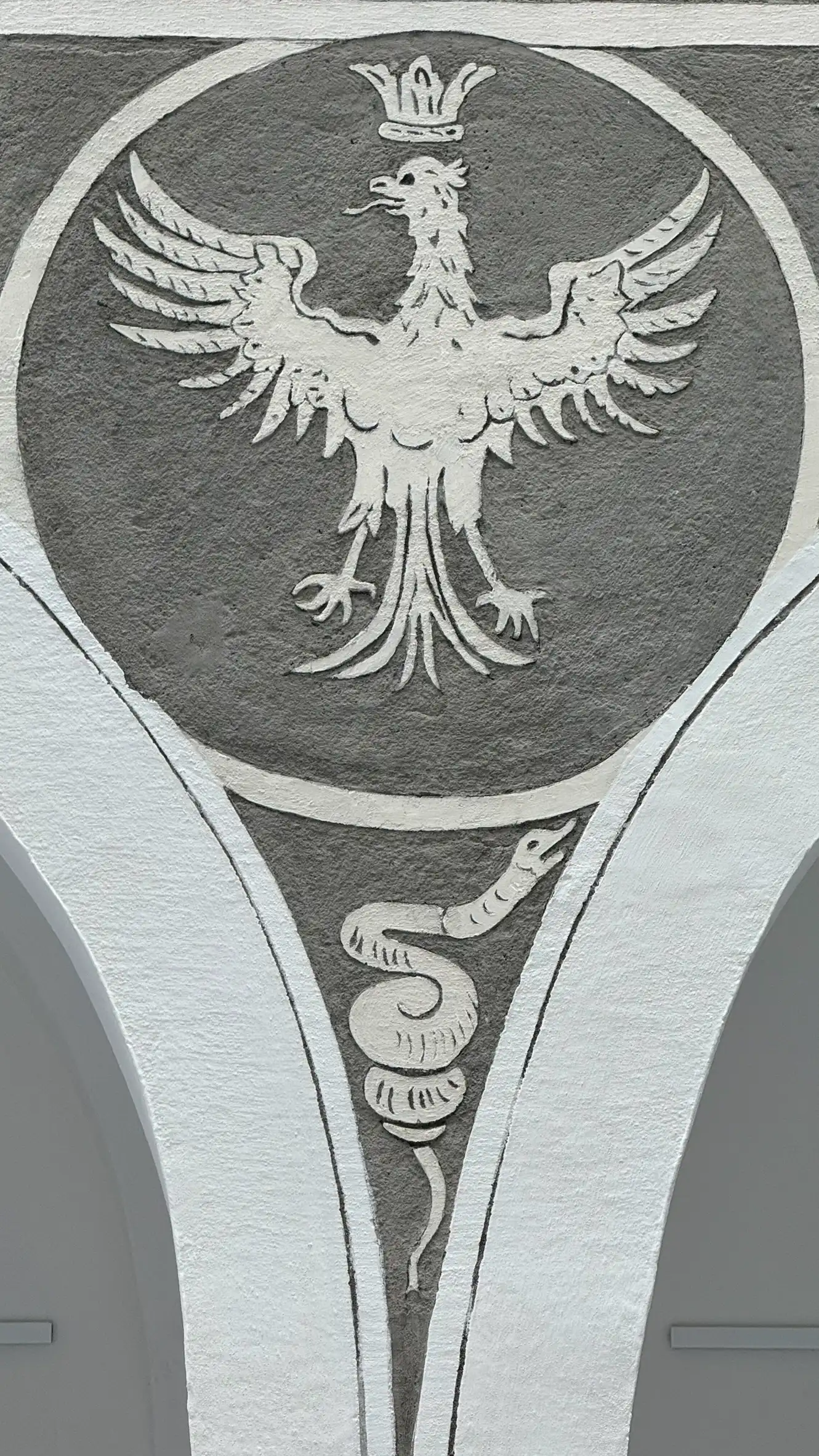 Spandrel-Detail: gekrönter Adler in einem Ring, darunter eine Schlange.