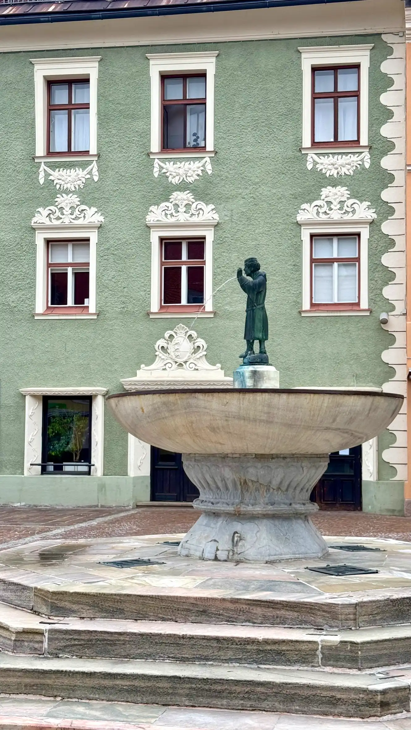 Bottom to top: polygonal stepped base, pedestal, large marble basin, cylindrical plinth, bronze figure