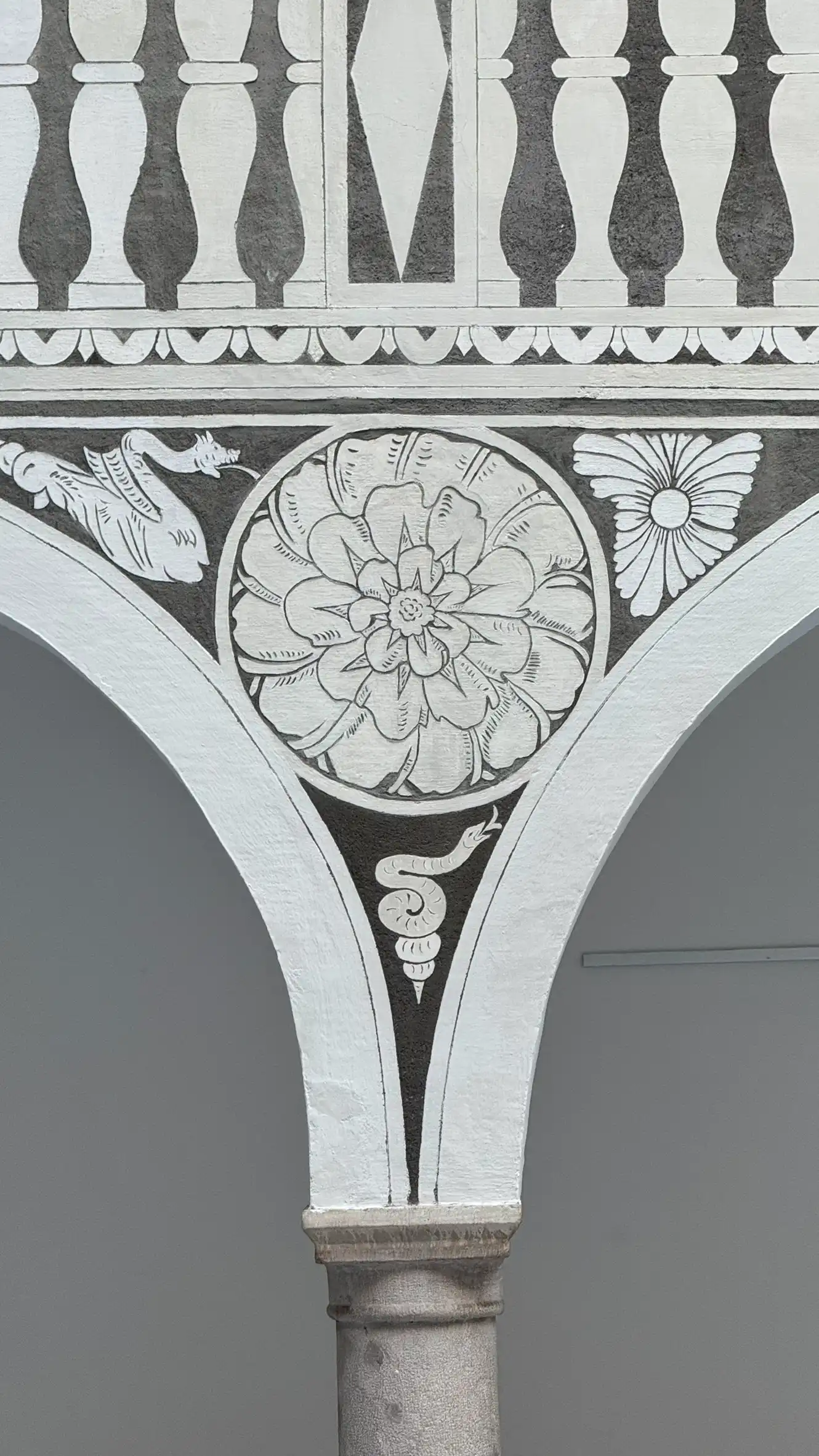 Monochromes Sgraffito mit Blumen- und Schlangenmotiv in einem barocken Zwickel.