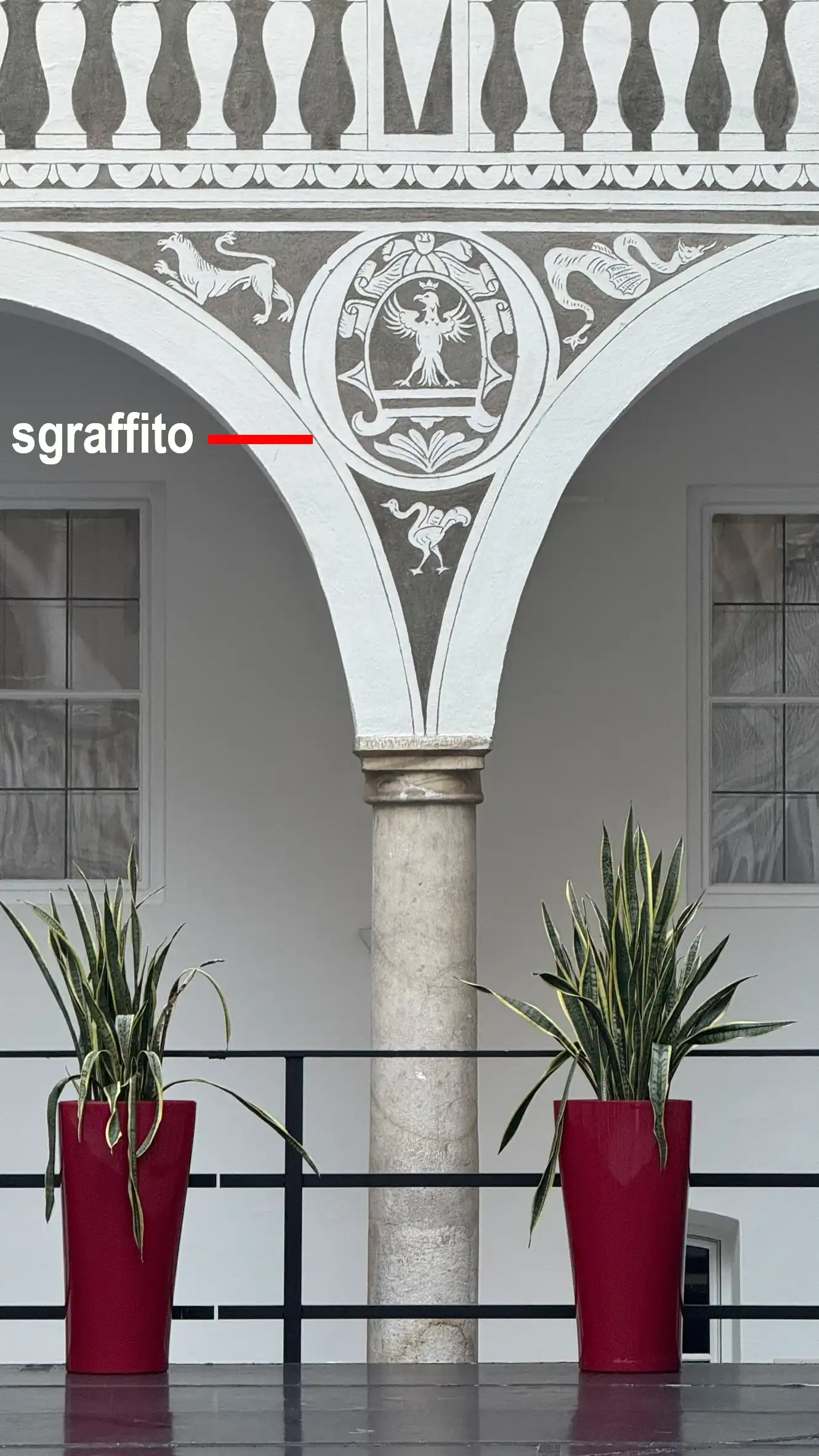 Decorative sgraffito adorns the spandrels above the arches. A spandrel is the triangular space between two adjacent arches.