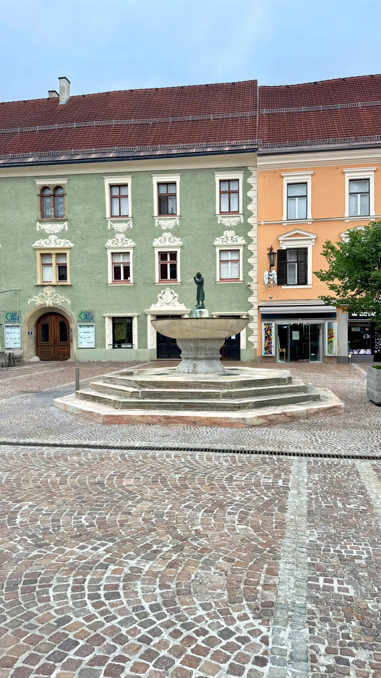 The fountain is located towards the eastern end of the main square.