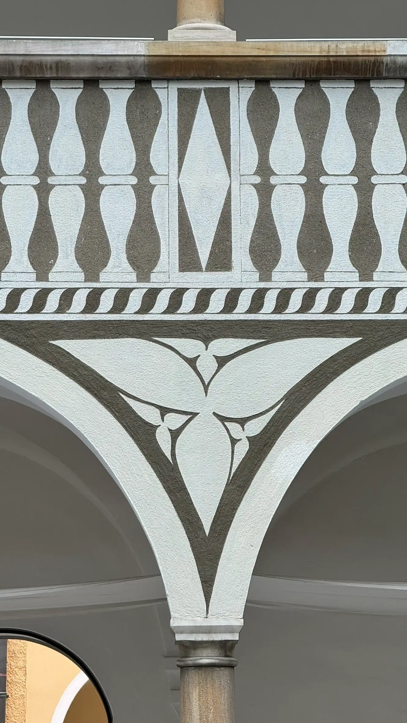 Sgraffito an der Balustrade mit vertikalen Balustern; florale Motive im Zwickel.