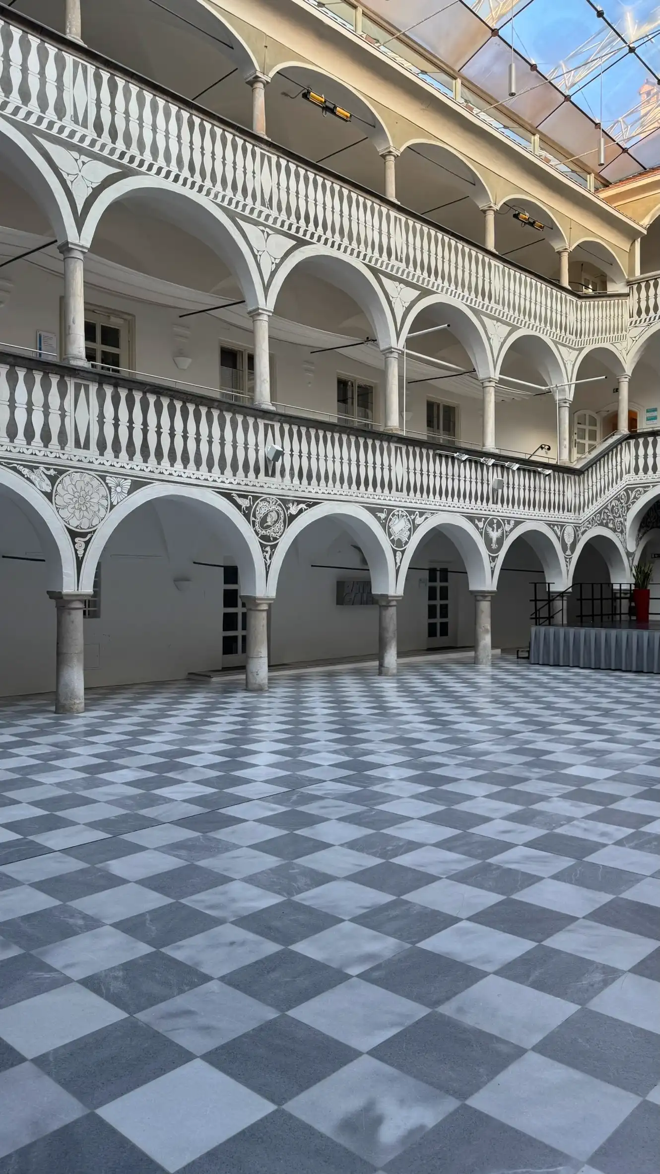 The courtyard floor is paved in chequerboard marble.