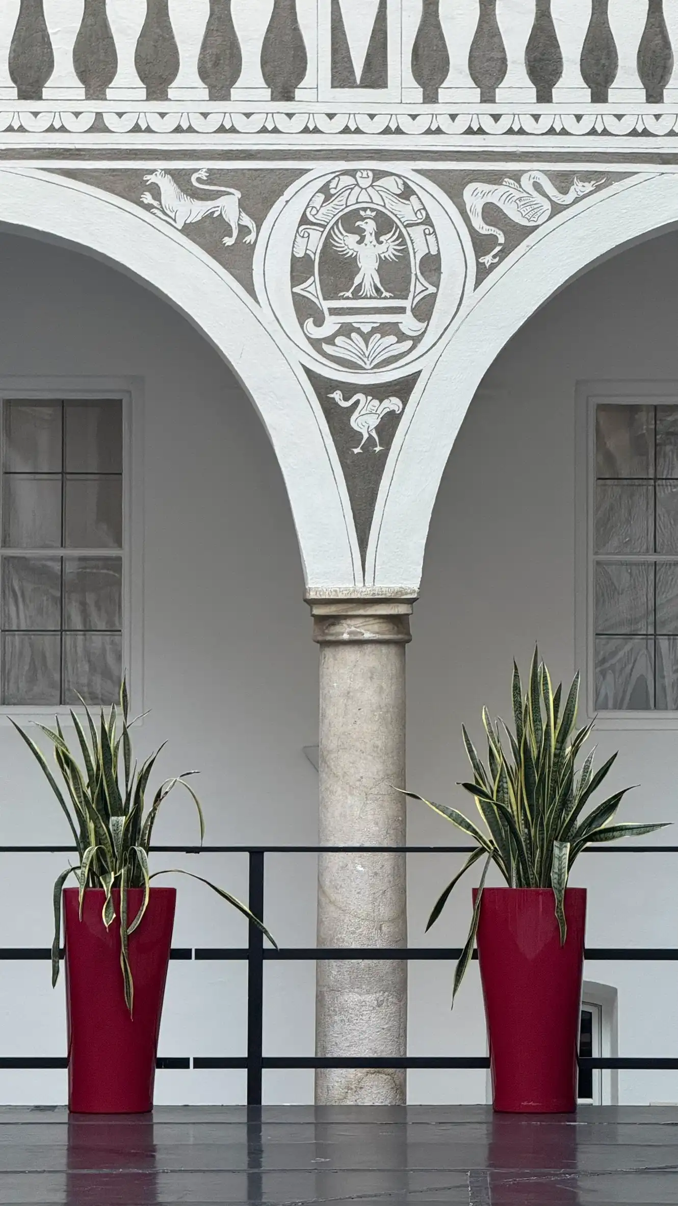 Sgraffito im Zwickel mit einem gekrönten Adler als Zentralmotiv, umgeben von drei tierähnlichen Darstellungen.