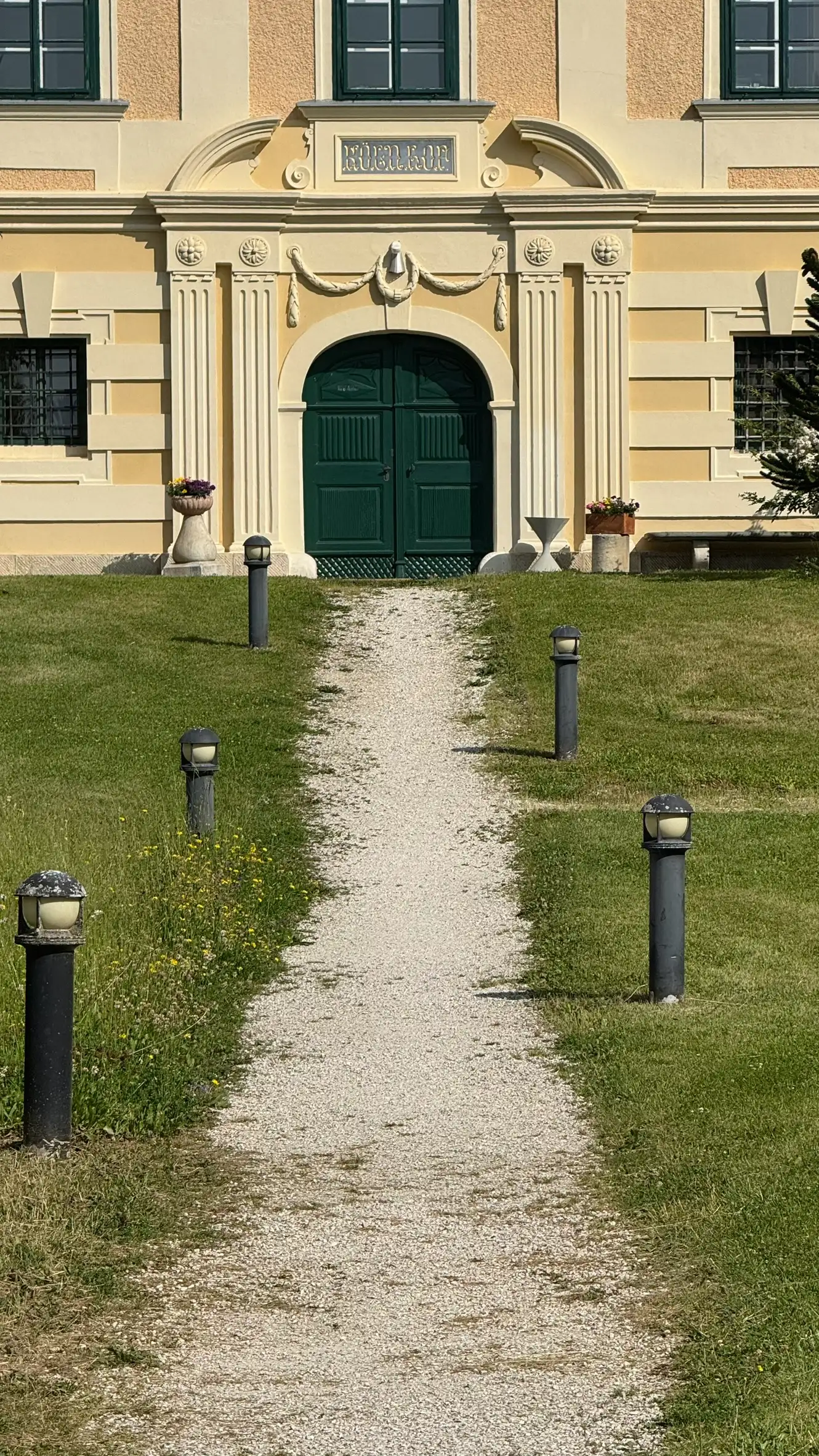 Bogenportal: von doppelten Pilastern flankiert, Flechtverzierung (Zopfstil) und gebrochener Giebel